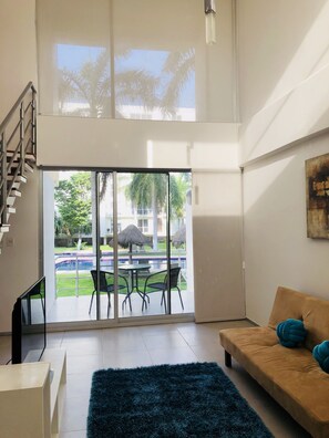 Departamento de diseñador, 2 habitaciones, vista a la alberca, junto a la alberca | Área de sala de estar | Televisión de pantalla plana de 45 pulgadas con canales vía satélite 