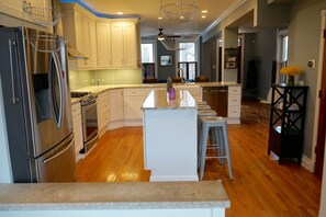 A modern kitchen with white cabinets, stainless steel appliances, and a central island. - 3-Level Bucktown Home - Amazing Outdoors & Parking (Chicago)