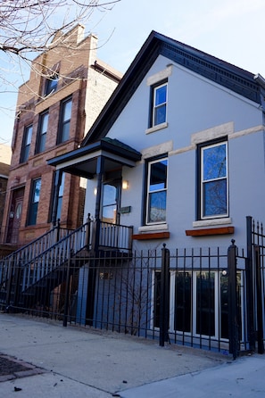 A row of residential buildings with a mix of architectural styles, including a brick building and a modern facade with large windows. - 3-Level Bucktown Home - Amazing Outdoors & Parking (Chicago)