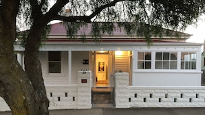 A white two-story house with a number 29 sign at the entrance, a front porch, and a small front yard. - Signature on Gunn (Devonport)