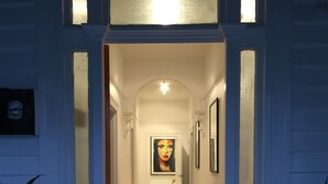 A hallway with a 'HOME' mat at the entrance, a framed picture on the wall, and a small stool with a bag. - Signature on Gunn (Devonport)