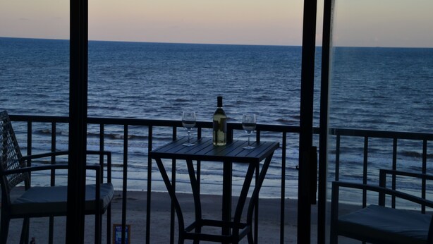 Una terraza frente al mar con mesa y sillas, con vistas al océano.