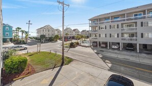 A multi-story residential building with a parking area in front.
