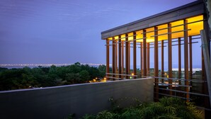 A modern building with a balcony overlooking a cityscape at dusk. - Queens Suite by D Imperio Homestay (George Town)