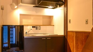 A compact kitchen with a built-in dishwasher, a sink, and a stove. - Koume no Hanare (Kyoto)