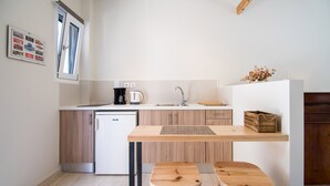A compact kitchen with a refrigerator, sink, and wooden stools. - CASA BUGANVILLA 5 in Minia (Argostoli)