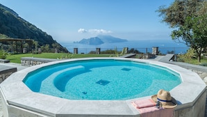 Una piscina con vista sul mare e sulle montagne.