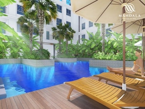 Una piscina al aire libre, sombrillas, sillones reclinables de piscina