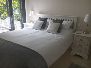 Cozy retreat with a large bed, nightstand, and window for natural light.