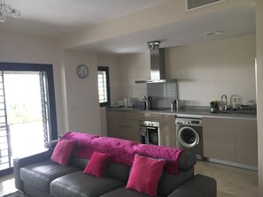 Relax in this stylish living space with a sofa, kitchenette, and oven.