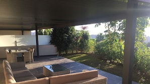 Un espace extérieur aménagé avec un ensemble de canapés, une table et des chaises.