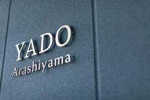 A close-up of a metallic sign with the text 'YADO' and 'Arashiyama' on a textured surface. - YADO Arashiyama (Kyoto)