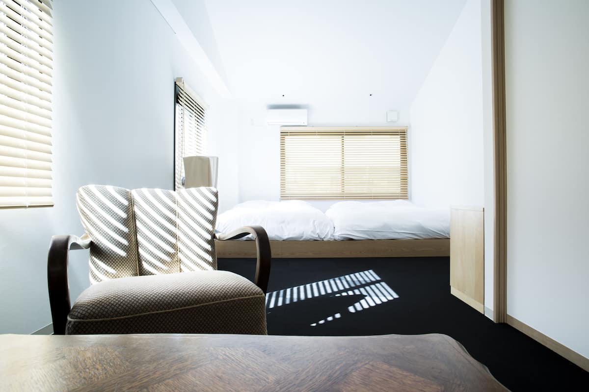 A compact room with a bed, a chair, and a table.
