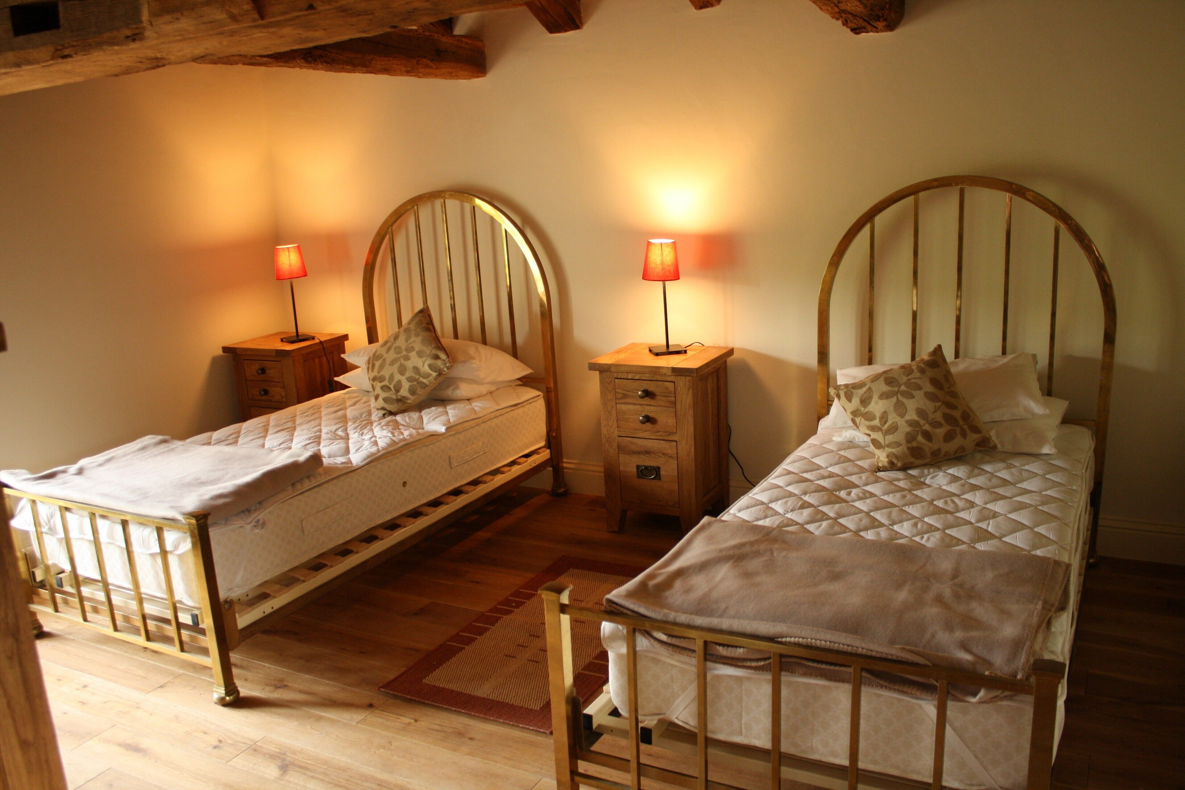 Two single beds with headboards, wooden nightstands, and lamps.
