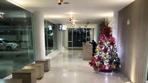 A modern lobby with a polished floor, a Christmas tree, and a reception desk. - TIVOLI 3 BEDROOM APARTMENT, NEAR BUENAVISTA. (Barranquilla)