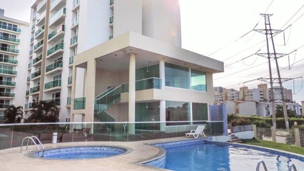 A modern building with a swimming pool, glass railings, and a staircase leading to the upper floors. - TIVOLI 3 BEDROOM APARTMENT, NEAR BUENAVISTA. (Barranquilla)