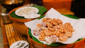 A table with a plate of snacks and a bowl of soup.