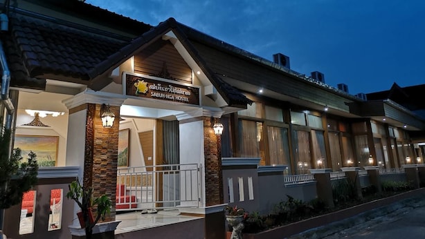 A hostel with a signboard, a covered entrance, and a well-lit facade.