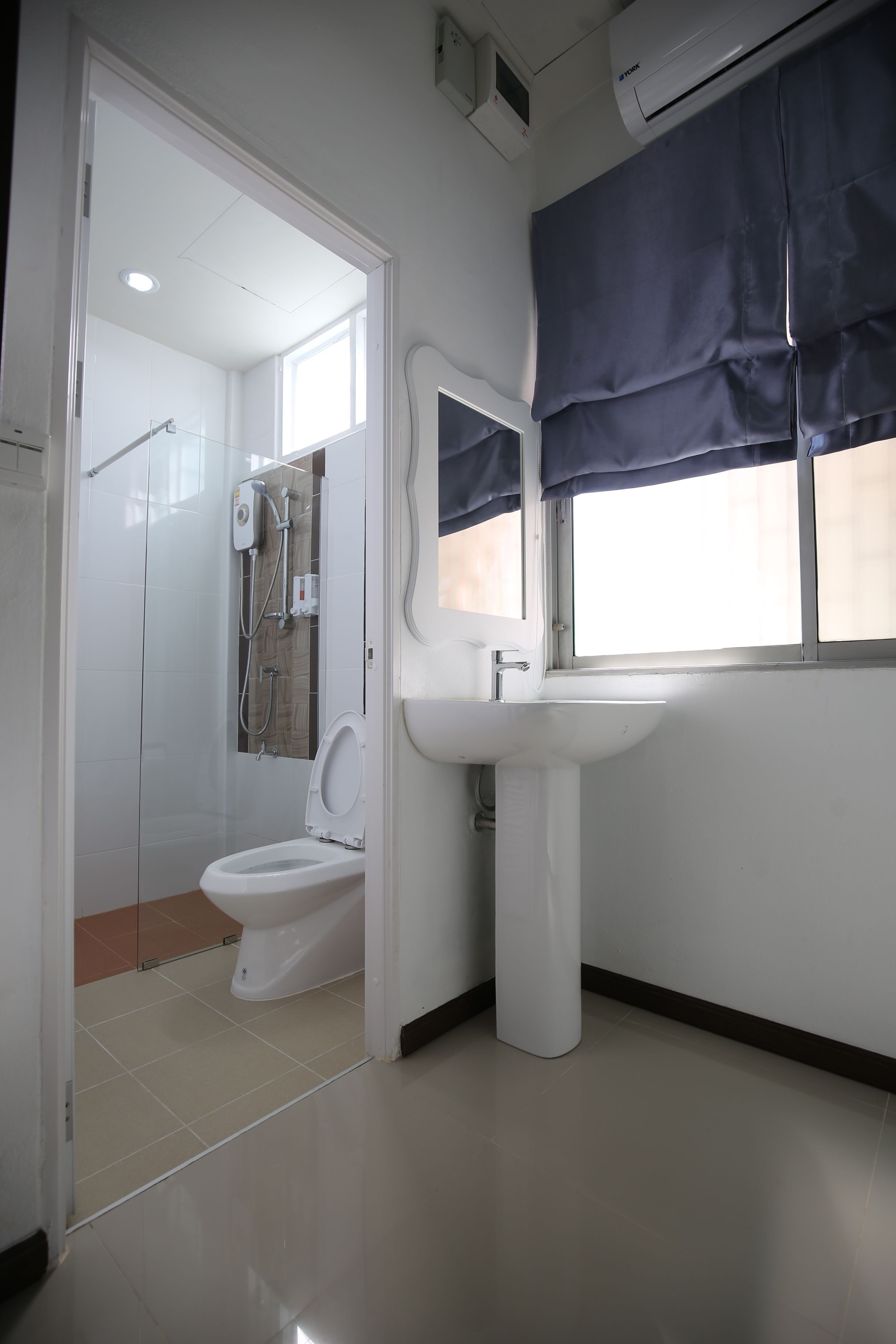 Un baño con inodoro, lavabo y ducha.
