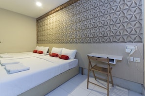 Une chambre d’hôtel avec un lit, un bureau et un mur orné d’un motif géométrique.