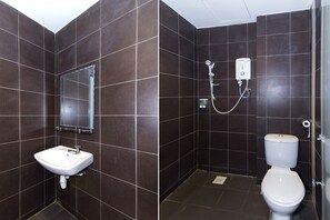 A bathroom with a white sink, a mirror, a shower, and a toilet. - Simms Grand Inn (Kuala Lumpur)