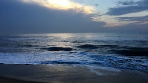 Une plage avec des vagues et un ciel nuageux.