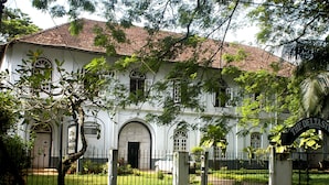 Un bâtiment blanc avec un toit recouvert de tuiles rouges, des fenêtres en arc de cercle et une enseigne sur laquelle on peut lire « The Deltsast ».