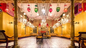 Une pièce ornée de lustres somptueux, dotée d’un autel central et d’un mobilier traditionnel.