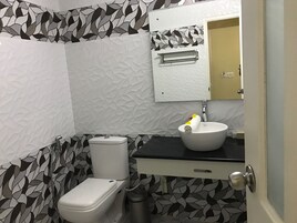 A bathroom with a toilet, sink, and mirror.