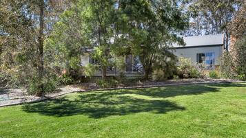 A house with a well-maintained lawn and trees in the background.