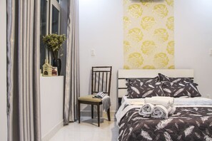 A neatly arranged bedroom with a bed, a chair, and a window with curtains.