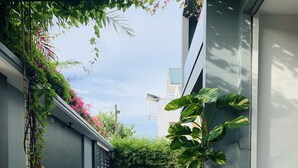 Een moderne buitenruimte met een zwembad met glazen bodem, omgeven door weelderig groen en planten.