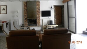 A living room with a fireplace, a television, and a large window.