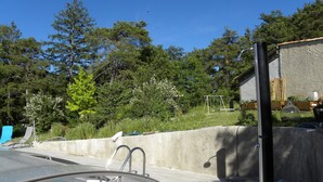 A swimming pool with a concrete deck, a metal ladder, and a metal railing.