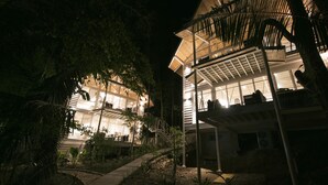 Un edificio moderno con diversi livelli e ampie finestre, immerso nel verde.