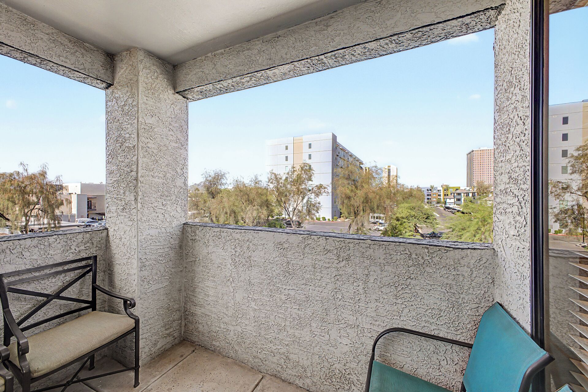 A balcony with a view of buildings and trees.