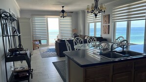 A kitchen with a large island, white cabinetry, and a view of the ocean. - Gulf Front Condo, Corner Unit, Stunning Views, Great Restaurants (Panama City Beach)