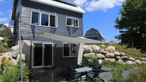 A modern house with a patio area featuring outdoor furniture and a solar panel on the roof.