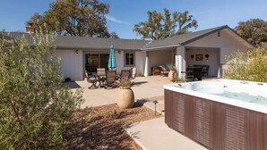 A house with a patio, outdoor seating, and a hot tub.