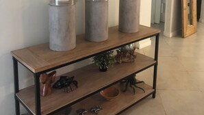 A wooden console table with three glass vases, a mirror, and decorative items. - Vanderbilt Beach Vacation Home - LARGE PRIVATE POOL w/ fully fenced in backyard (Naples)