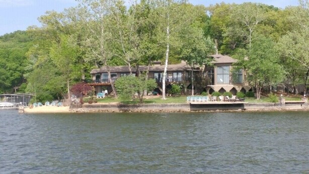 A lakeside cabin with a dock, surrounded by trees and a clear view of the water. - Private Paradise spot !!  (Osage Beach)
