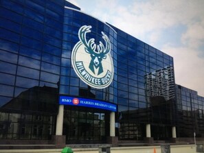 A modern building with a large logo of a deer and the text "Milwaukee Bucks" on the facade. - Spectacular! Professionally Cleaned, Self Check In - Sleeps 8  (Racine)