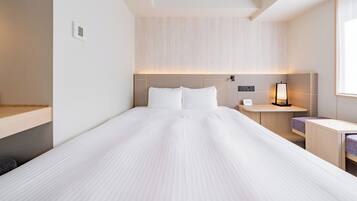 Quarto de hotel moderno com uma cama grande, mesas de cabeceira e uma janela.
