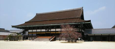 A traditional Japanese building with a tiled roof, wooden structure, and a staircase leading to the entrance.