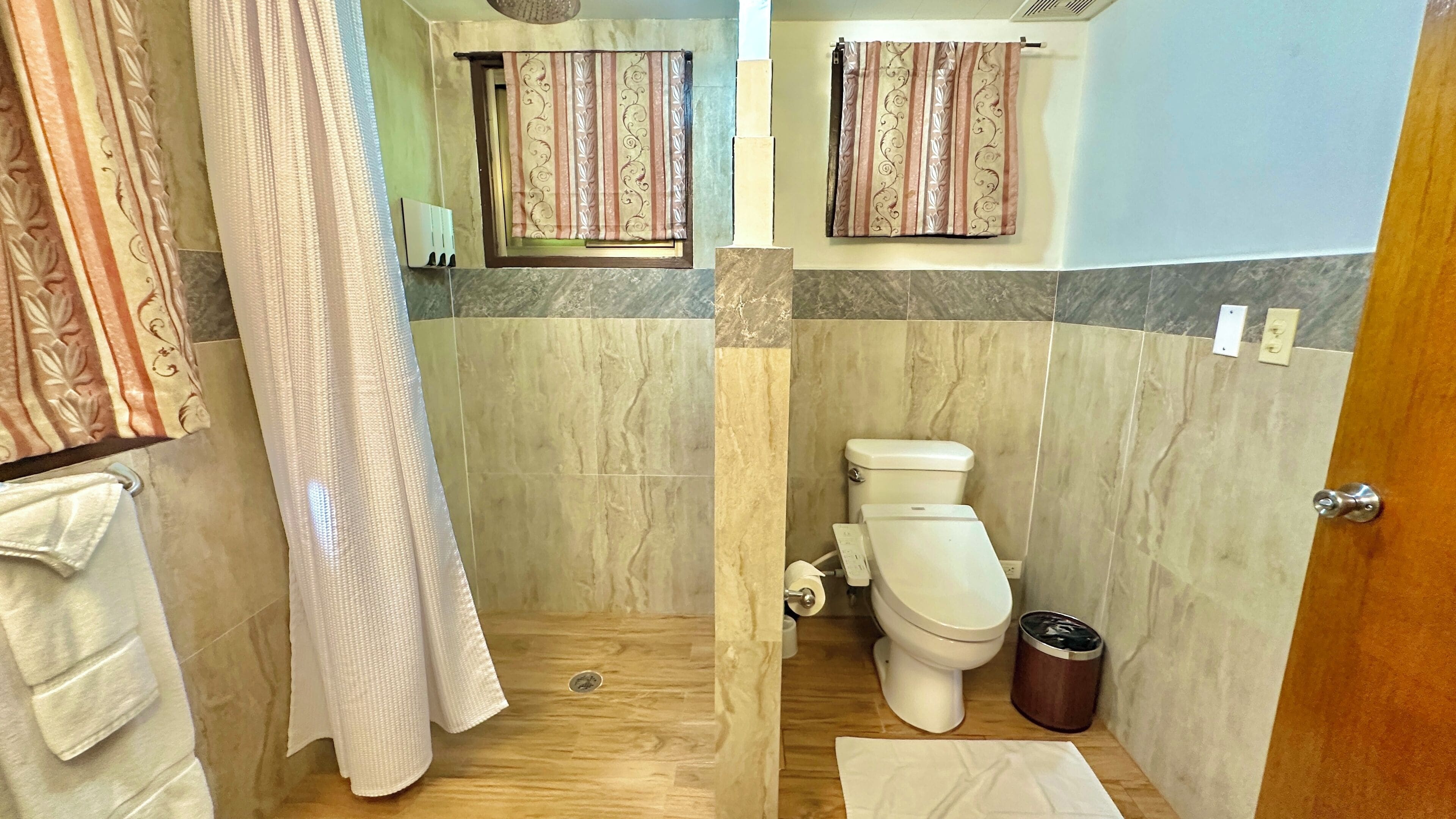 A bathroom with a shower, toilet, and a sink.