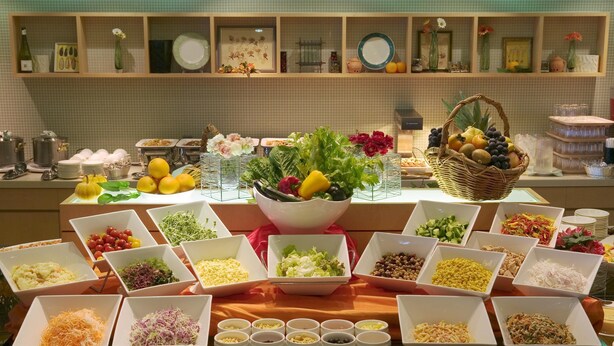 Une table de buffet garnie de divers plats et agrémentée d’un panier décoratif.