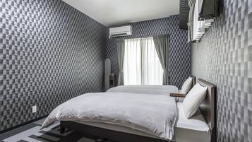 Ein modernes Hotelzimmer mit kariertem Wandmuster, einem Bett mit weißen Leinen und einer Klimaanlage an der Wand.