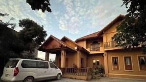 Un edificio di due piani con un portico coperto e un'auto parcheggiata davanti.