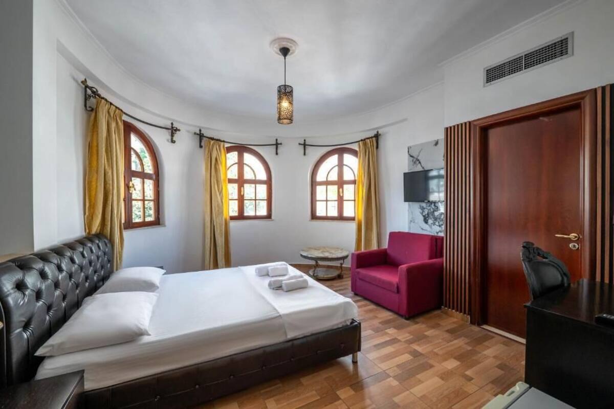 Un dormitorio con cama, escritorio, silla y una mesita.
