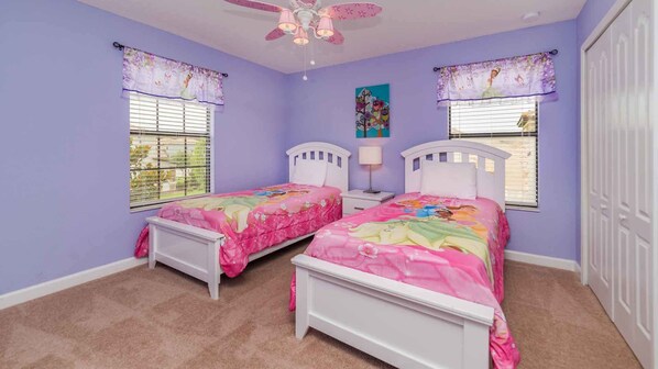 Un dormitorio con dos camas individuales, un ventilador de techo y dos ventanas con persianas.